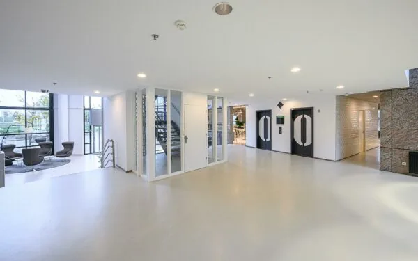 Moderne en lichte ontvangsthal van het Rivium Quadrant met zitgedeelte, trappenhuis en liften.